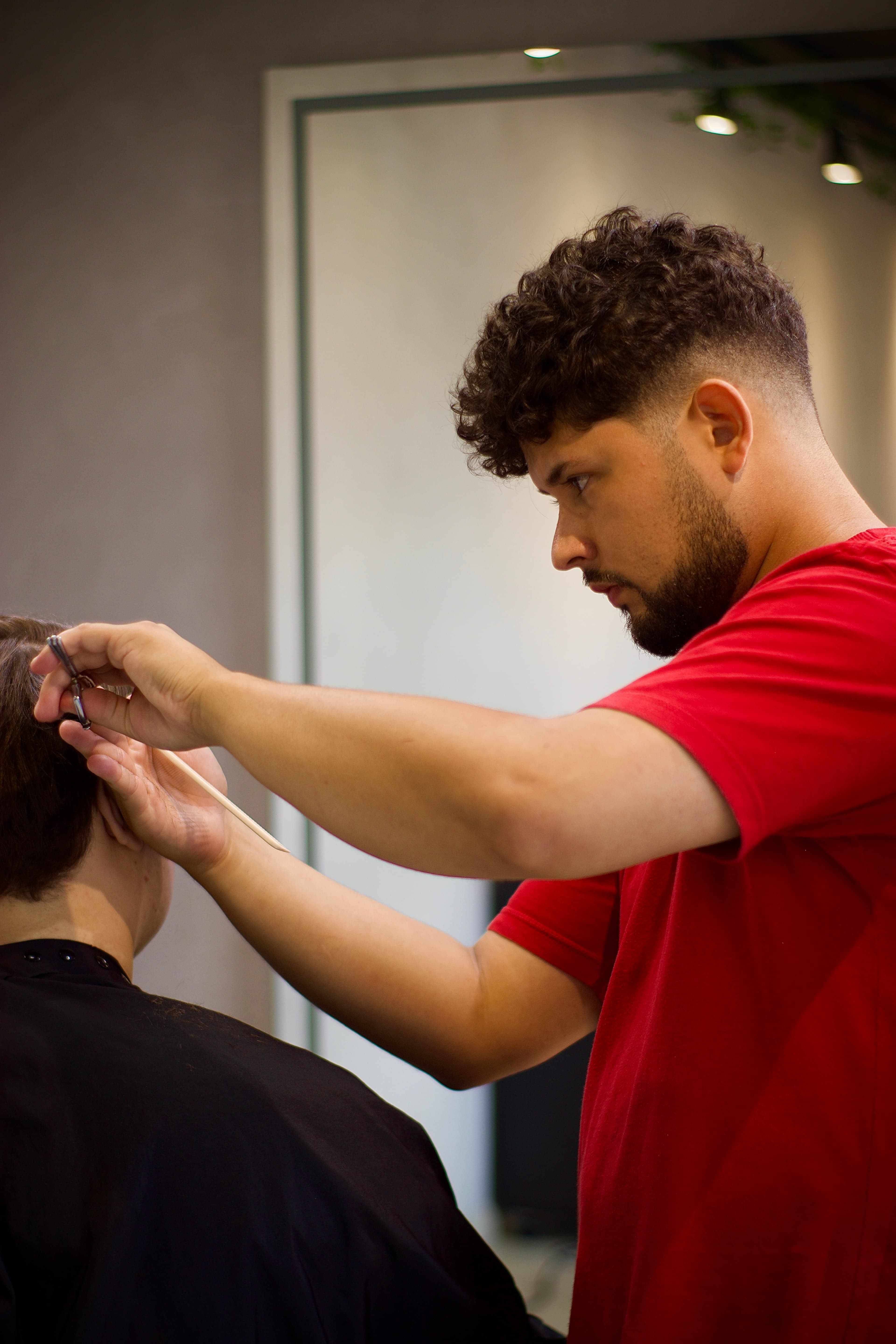 Bruno de Carli cortando o cabelo de um cliente
